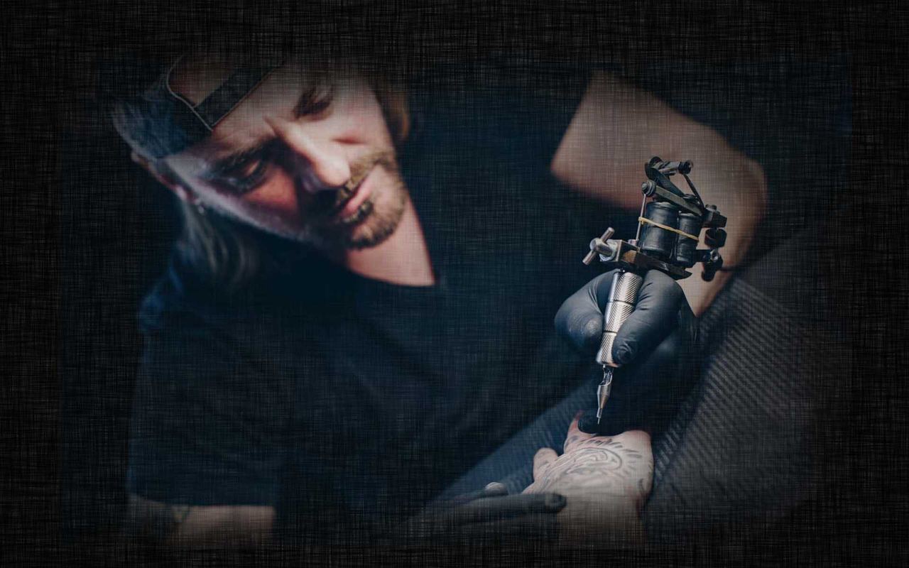Oliver Sasin tätowiert konzentriert mit Tattoomaschine