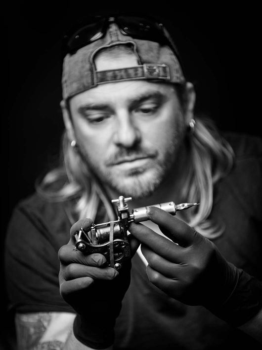 Oliver Sasin mit Tattoomaschine, Schwarz-Weiß-Porträt