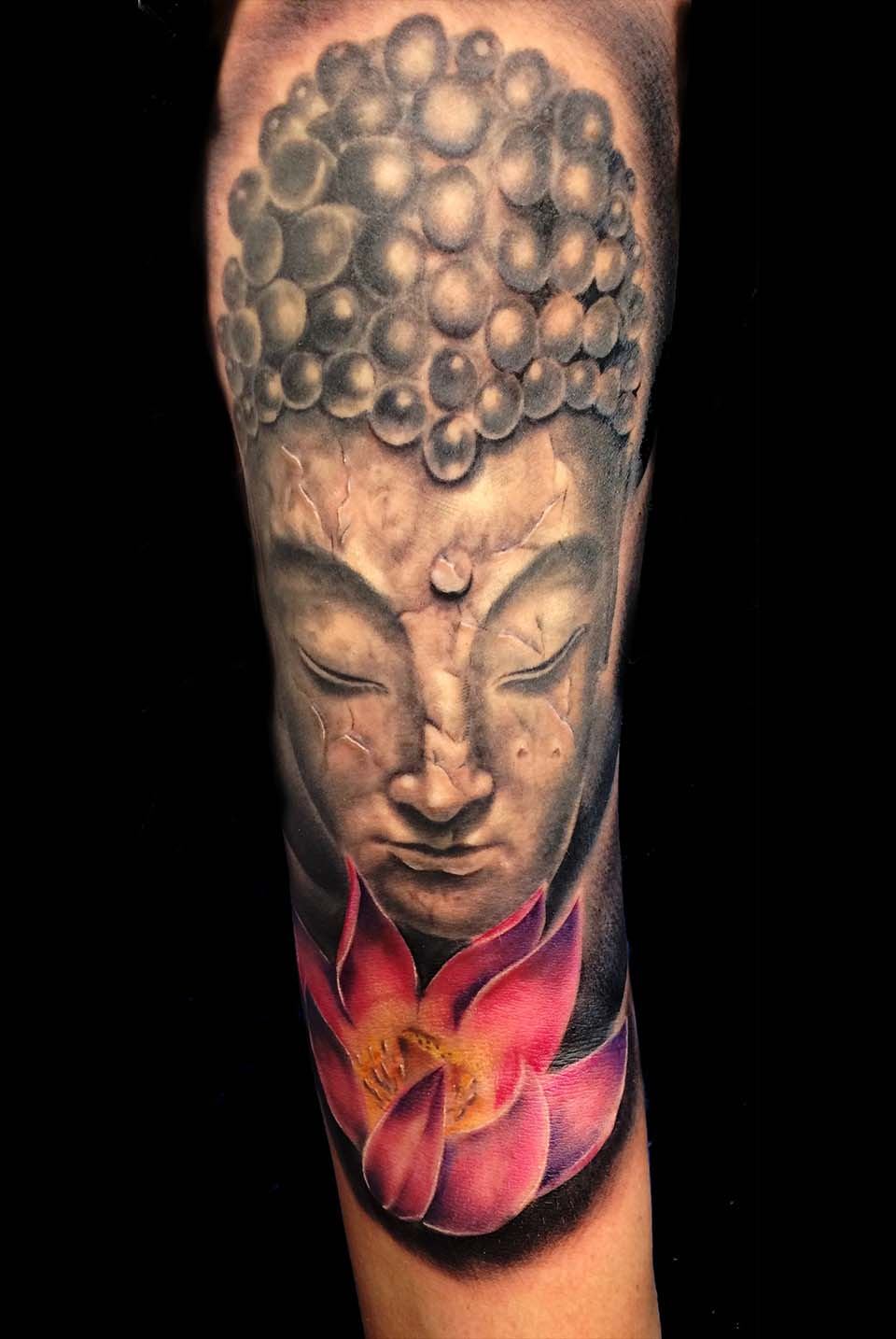 Buddha mit pinkfarbener Lotusblüte am Arm