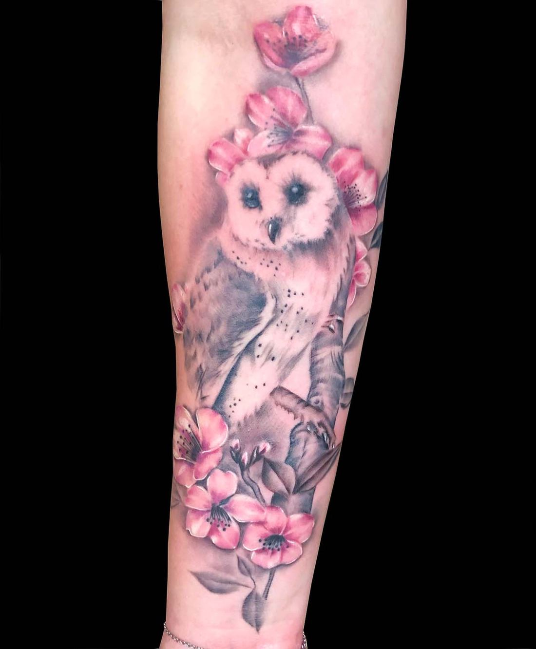 Eule mit rosa Blüten am Unterarm