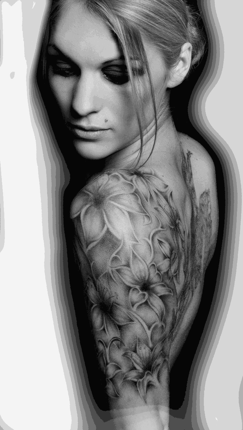 Schwarz-Weiß-Foto einer Frau mit großflächigem Black-&-Grey-Tattoo an Schulter und Arm